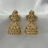 Gold earrings on a white satin background