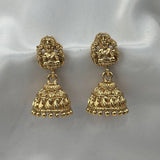 Pair of gold earrings on a white fabric background