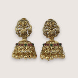 Pair of gold earrings with intricate designs and colored stones on a light beige background