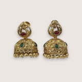 Pair of gold earrings with intricate designs on a light beige background
