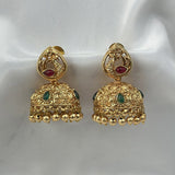 Gold earrings with red and green stones on a white background