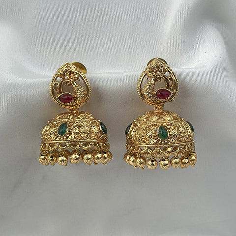 Gold earrings with red and green stones on a white background