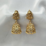 Pair of gold earrings on a white satin background