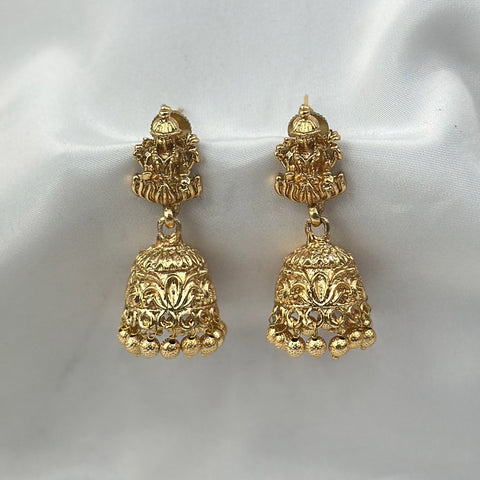 Pair of gold earrings on a white satin background