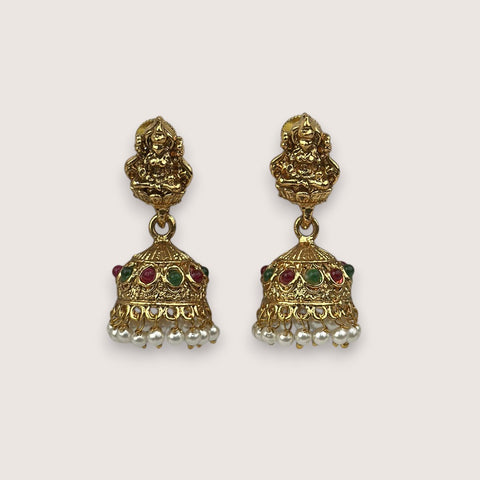 Pair of gold earrings with intricate designs and gemstones on a white background