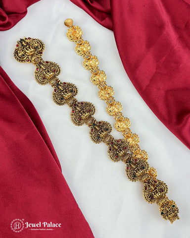 Gold necklace with intricate designs on a red and white fabric background, featuring the Jewel Palace logo.