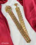 Gold necklace with red stones on a red fabric background
