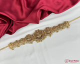 Gold decorative belt with intricate designs on a red fabric background