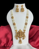 Gold necklace and earrings set on a mannequin bust with red fabric background