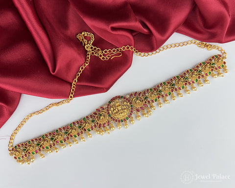 Gold necklace with gemstones on a red fabric background