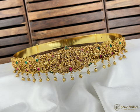 Gold jewelry with gemstones on a white fabric background