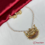 Gold necklace with peacock design on a red and white fabric background, featuring the Jewel Palace logo.