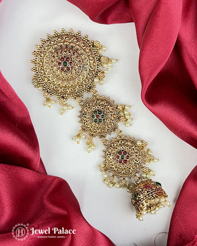 Ornate gold earrings with red and green gemstones on a red fabric background, featuring 'Jewel Palace' branding.