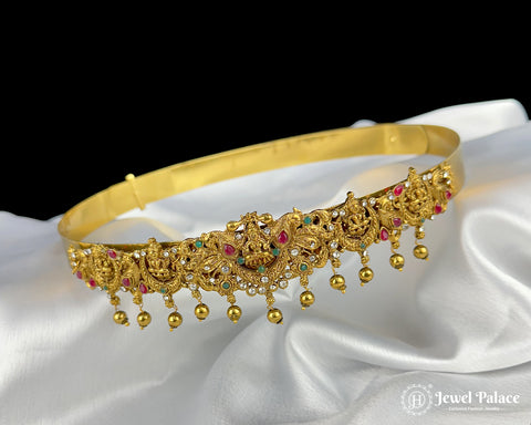 Gold necklace with gemstones on a white satin background, brand 'Jewel Palace' visible