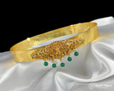 Gold headband with green gemstones on a white satin background