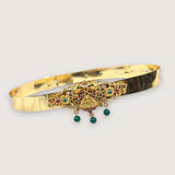 Gold bracelet with gemstone accents on a light gray background