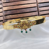 Gold headband with decorative elements and green beads on a white fabric background