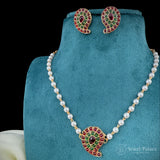 Pearl necklace with gemstone pendant and matching earrings on a blue stand, brand 'Jewel Palace' visible.