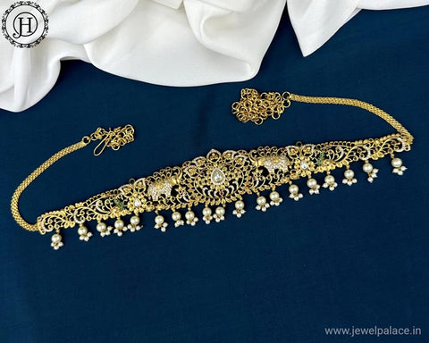 A gold-plated hip chain with AD stones, designed with intricate patterns and small pearls, displayed on a blue background.