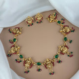 Gold necklace with green and red gemstones on a white background