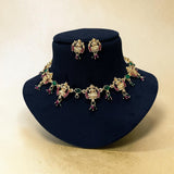 Jewelry set with necklace and earrings on a black stand against a beige background