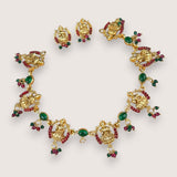 Gold jewelry set with emeralds and rubies on a white background