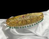 Gold headband with gemstones on a white fabric background