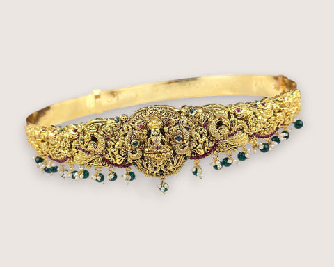Gold jewelry with gemstones on a light gray background