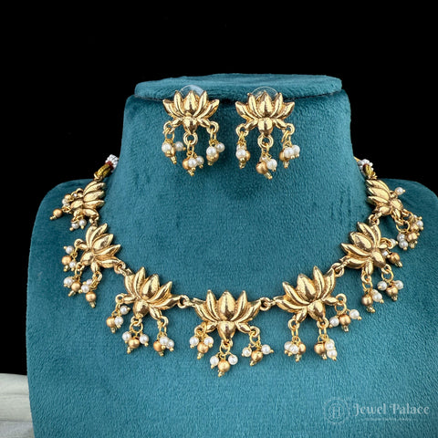 Gold necklace and earrings set on a teal stand with 'Jewel Palace' branding.