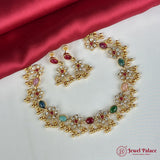 Gold necklace and earrings with gemstones on a red satin background, featuring 'Jewel Palace' logo.