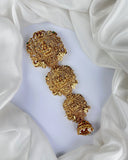Gold floral earrings on a white fabric background