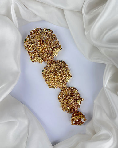 Gold floral earrings on a white fabric background