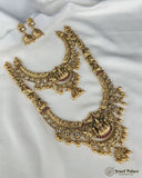 Gold necklace and earrings set on a white fabric background