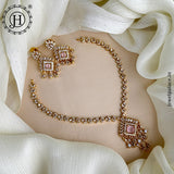 Gold necklace and earrings on a white fabric background with Jewel Palace logo.