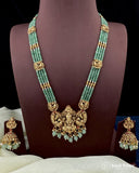 Green beaded necklace with gold accents on a mannequin, accompanied by matching earrings.