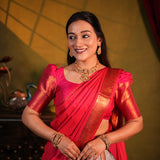Woman in a red saree with gold blouse against a blurred background