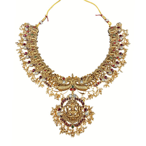 Gold necklace with intricate design and red and white stones on a white background