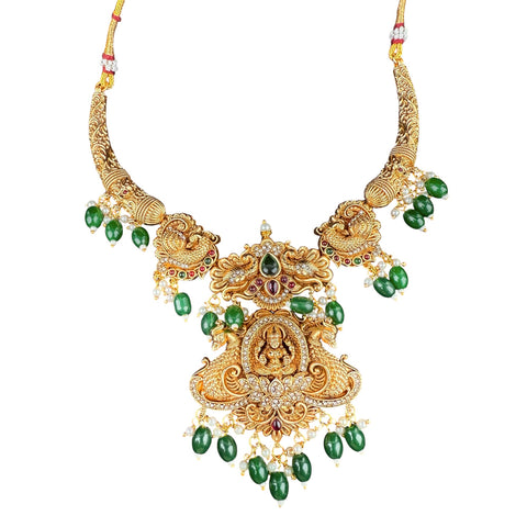 Ornate gold necklace with green gemstones on a white background