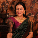 Woman in traditional attire with jewelry against a decorative background