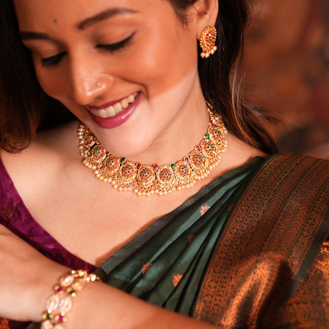 Woman wearing traditional jewelry including a necklace, earrings, and bangles.