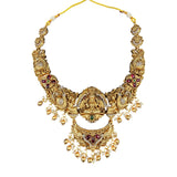 Gold necklace with intricate design and gemstones on a white background