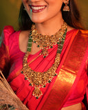 Woman wearing traditional gold jewelry and a red saree with a green background