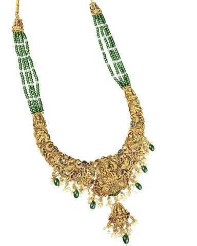 Gold necklace with green beads on a white background