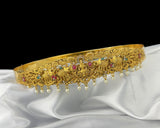 Gold tiara with gemstones on a white fabric background