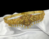 Gold headband with intricate designs and colorful stones on a white fabric background