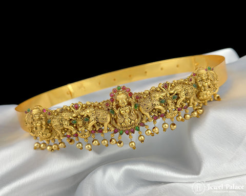 Gold headband with elephant designs and gemstones on a white fabric background
