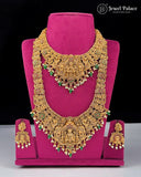 Gold necklace set with green and red stones on a pink stand, brand 'Jewel Palace' visible.