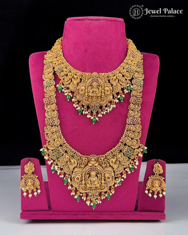 Gold necklace set with green and red stones on a pink stand, brand 'Jewel Palace' visible.