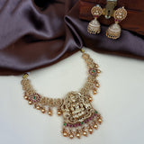 Gold necklace and earrings on a white surface with brown fabric background