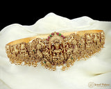 Gold jewelry piece with intricate designs on a white fabric background